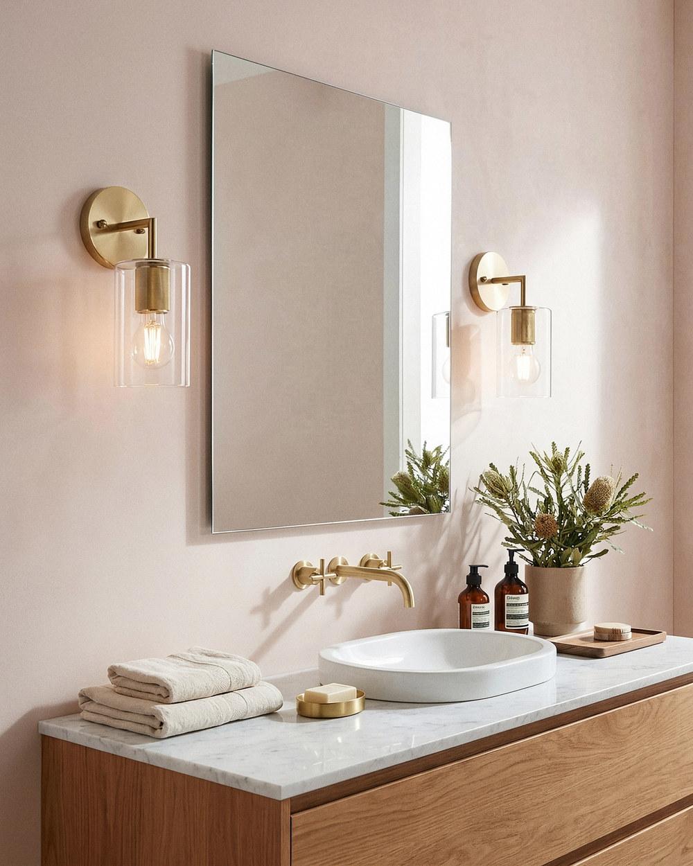Selwyn contemporary wall lights in satin brass either side of a bathroom mirror