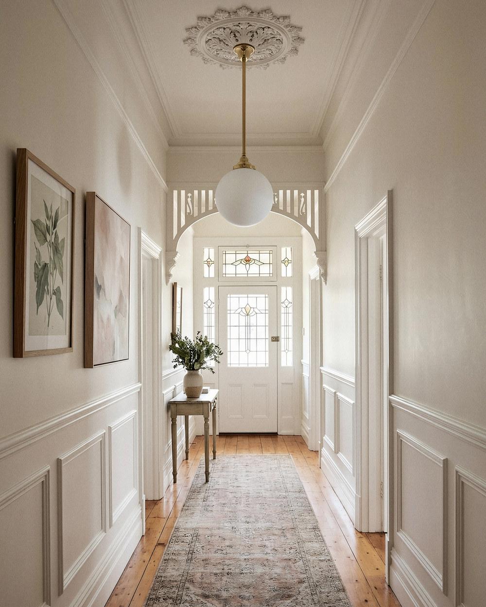 Sphere opal glass pendant on a solid-brass rod in a period hallway